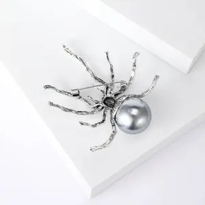 Makro-Detail einer Vintage-Silber-Spinnenbrosche mit großer glänzender grauer Perle