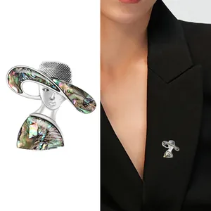 Elegant silver female portrait brooch with abalone shell hat shown on a black suit
