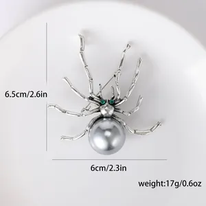 Gotische silberne Spinne-Brosche mit grauer Perle und grünen Strassaugen auf Teller