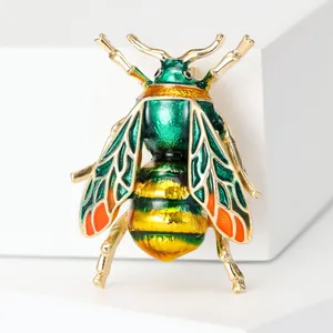 Macro detail of the honeybee brooch featuring colorful enamel wings and golden plating
