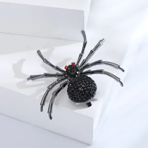 Makro-Detail einer Gothic-Spinnenbrosche mit schwarzen Strasssteinen und roten Augen