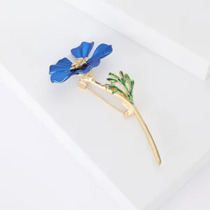 Vue détaillée de la broche fleur avec pétales en émail bleu et finition métal doré