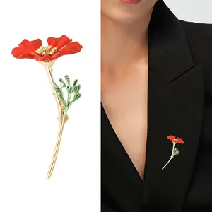 Élégante broche fleur rouge avec détails dorés et feuilles vertes sur revers noir