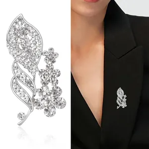 Elegant silver leaf and floral brooch with rhinestones shown on model and white background