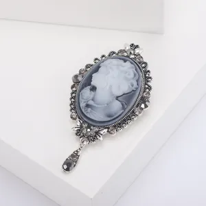 Detail of vintage cameo brooch with rhinestone embellishments and a teardrop pendant