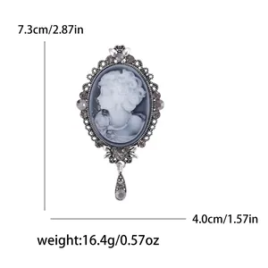 Vintage oval relief brooch with rhinestone border and teardrop pendant, 7.3cm height
