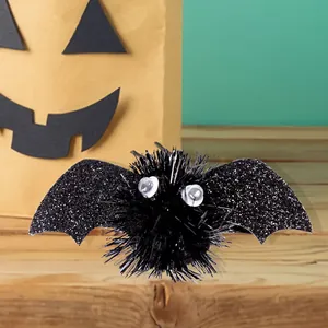 Close-up of glittery black bat hair clip with plush body for Halloween party styling