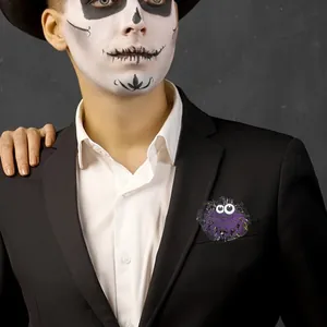 Dettaglio della spilla a ragno glitter viola sul bavero nero per festa di Halloween