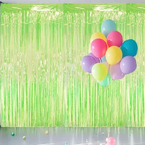 Shiny green foil fringe curtain background with colorful party balloons decoration