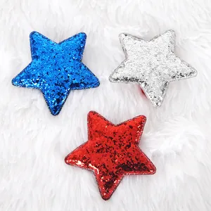 Close-up of patriotic sequin star hair clips in red, silver and blue on white faux fur