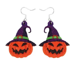 Glittery Halloween pumpkin earrings with purple wizard hats on white background