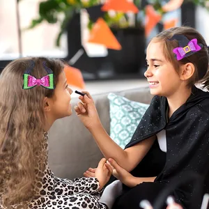 Dettaglio di bambine che indossano mollette per capelli a forma di cappello da strega e corna