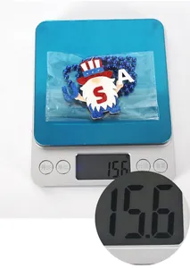 Detailed view of patriotic USA gnome necklace being weighed on a digital scale