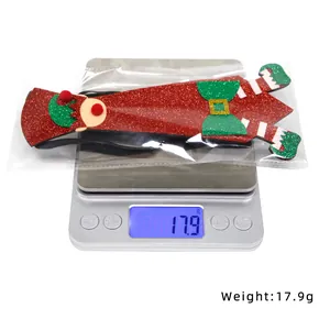 Détail d'un ornement d'elfe de Noël sur une balance numérique pesant 17,9g