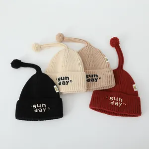 Mise à plat de bonnets en tricot noir, beige, kaki et rouge avec broderie Sunday