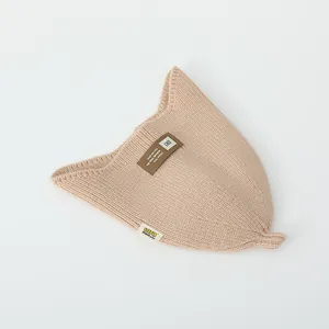 Detail of baby knit hat with letter patch and textured ribbed pattern in beige