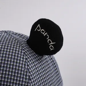 Macro detail of houndstooth toddler hat featuring plush panda ear and panda embroidery