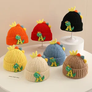 Detailed close-up showing variety of colorful knitted dinosaur beanies for children