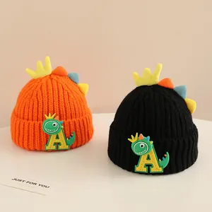 Winter kids knitted hats featuring cute cartoon dinosaur designs in orange and black