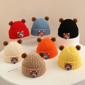 Dettaglio di cappelli in maglia per bambini con orecchie da orso in sette colori invernali