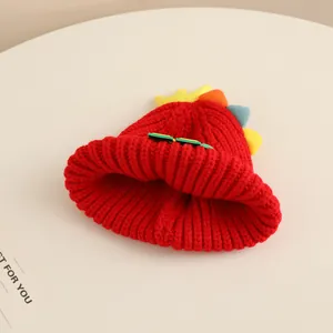 Detailed close-up of thick red knit winter hat featuring colorful dinosaur fins for kids