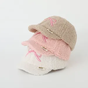 Close-up of soft fleece baseball caps with bow embroidery and bibicute label detail