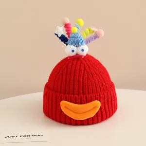 Detail of red monster knit hat featuring 3D eyes, spiral tentacles and plush mouth