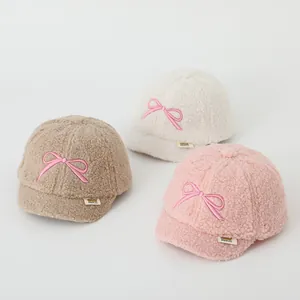 Close-up of soft fleece toddler baseball caps with bow embroidery in three colors