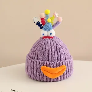 Close-up of purple knit monster hat with thick texture and colorful quirky 3D elements