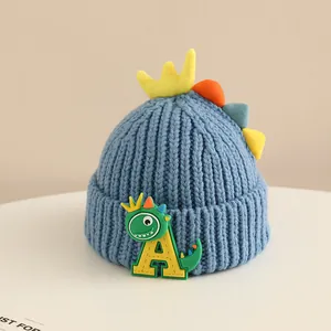 Detail of baby dinosaur knit hat featuring soft blue fabric and colorful back spikes