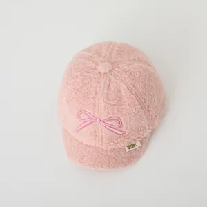 Close-up of pink polar fleece fabric and delicate bow embroidery on the kids baseball cap