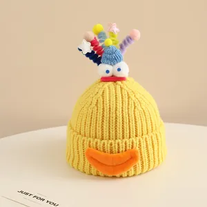 Detailed knit texture of a yellow monster hat with 3D eyes and colorful plush accents