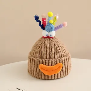 Detailed close-up of brown knit hat featuring funny monster eyes and colorful spiral decor