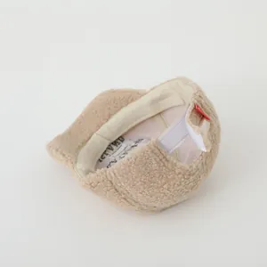 Detail of beige fleece baseball cap showing adjustable velcro strap and soft teddy texture