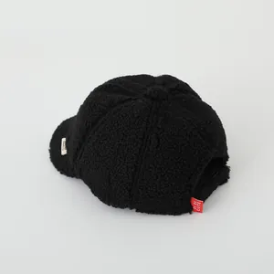Close-up of black sherpa fleece fabric texture and Di Di Cute brand woven label