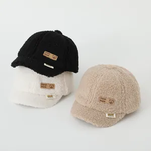 Close-up of winter fleece baby baseball caps with bear leather patch and soft texture