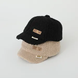 Detail of soft fleece texture on black and beige kids baseball caps with handmade patch