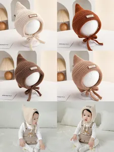Detail view of knit baby witch hats in four colors with chin straps and miu patch