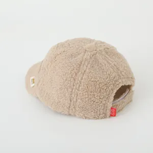 Detail view of beige fleece baseball cap showing warm texture and adjustable back strap