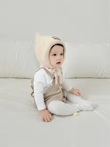 Detail of mushroom embroidery on a knitted baby romper and matching witch style hat