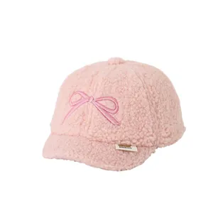 Pink fleece baseball cap for kids featuring a large bow and soft polar texture