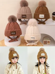 Detail of children's knit earflap hats with fluffy pom-poms in various autumn colors