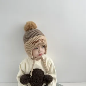 Detail of baby winter knit hat with earflaps, soft fleece lining, and Hello embroidery
