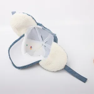 Detail view of winter earflap hat with warm lamb wool lining and corduroy fabric texture