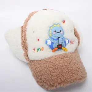 Detail of fleece winter earflap hat with cute dinosaur badge and embroidery