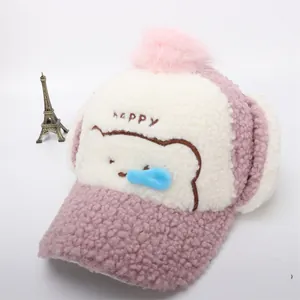 Dettaglio cappello invernale in pile rosa con paraorecchie e pompon morbido