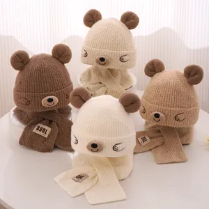 Détail d'un ensemble bonnet et écharpe en tricot ours pour bébé en divers tons