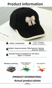 Detail of warm black fleece kids baseball cap with beige bow and white contrast brim