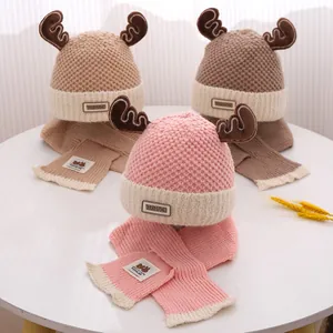 Detail van gebreide wintermuts en sjaalset voor baby's met schattig bruin hertengewei