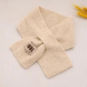 Détail d'une écharpe en tricot blanc crème pour bambins avec étiquette tissée de marque Soul